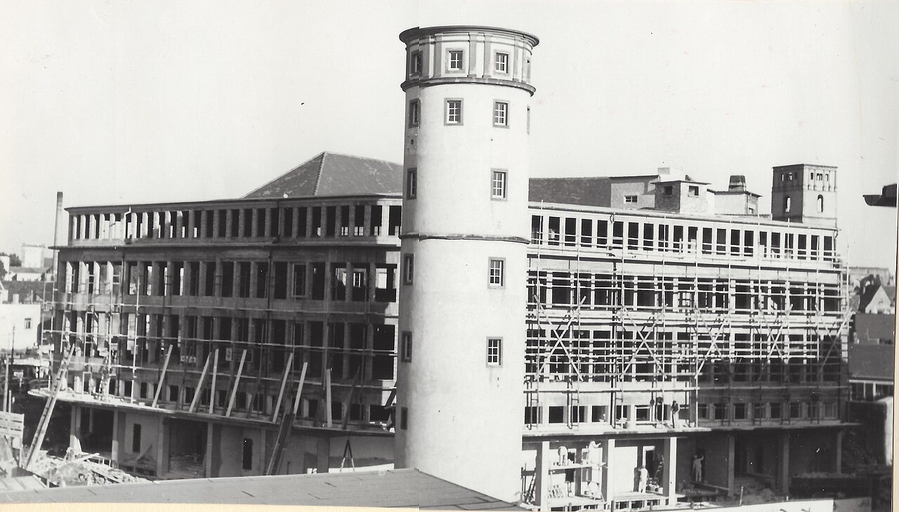 Der Neubau des Kaufhauses Henschel & Ropertz mit Weißem Turm im Vordergrund.